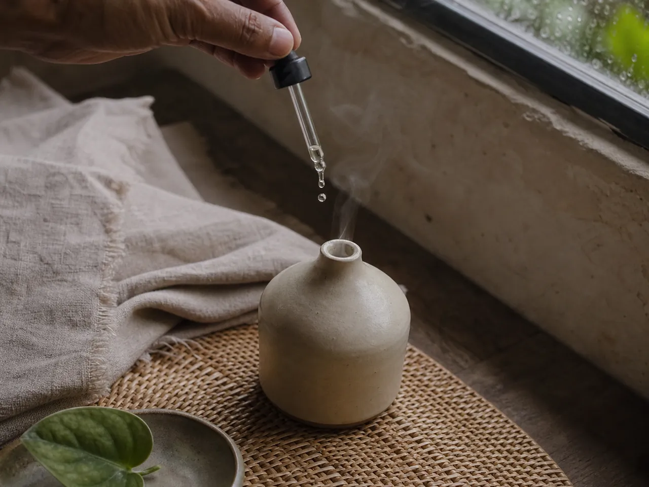 Minyak esensial diteteskan ke dalam diffuser keramik