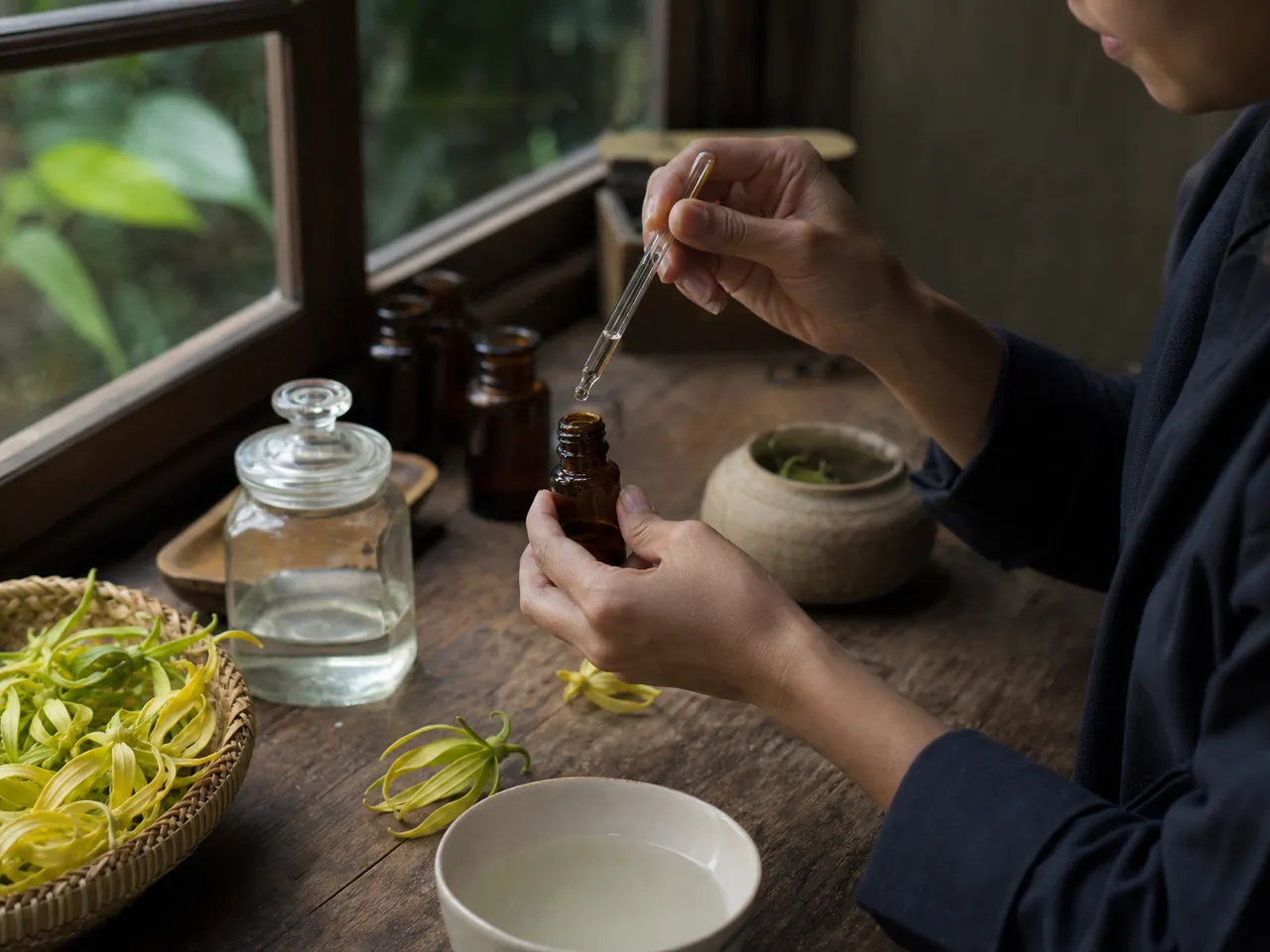 Peracik parfum meneteskan minyak atsiri ke dalam botol